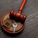 Why You Should Avoid A DIY Will - Judge gavel and key chain in shape of two splitted part of house on wooden background. Concept of real estate auction or dividing house when divorce, division of property, real estate, law system