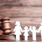Common Mistakes That Can Harm Your Child Custody Case - Family figures with gavel on brown wooden table