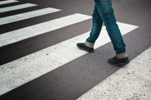 Pedestrian Accident Lawyer Nashua, NH - Legs of young woman in jeans and leather boots crossing street on zebra marking